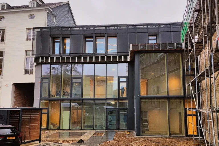 Ausbau Bürogebäude in Eupen: Altbau mit neuer Glasfassade und Gerüst