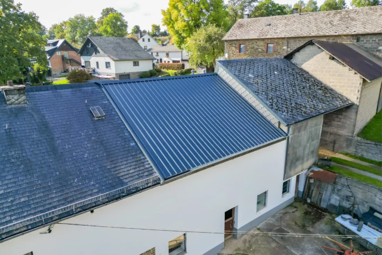 Dachsanierung: Teildach mit neuer Eindeckung aus Trapezblech neben Schieferdach