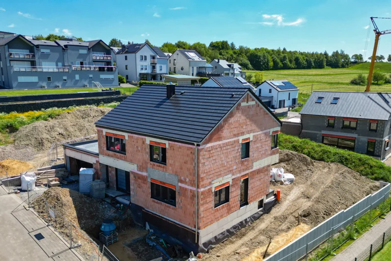 Dachstuhl und Eindeckung: Neubau mit Klinkerfassade und neuer dunkler Dacheindeckung, Luftaufnahme