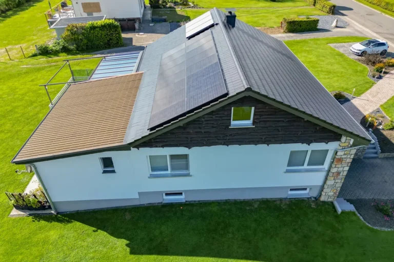 Wohnhaus mit neu eingedecktem dunklem Dach und Photovoltaikmodulen, Luftaufnahme