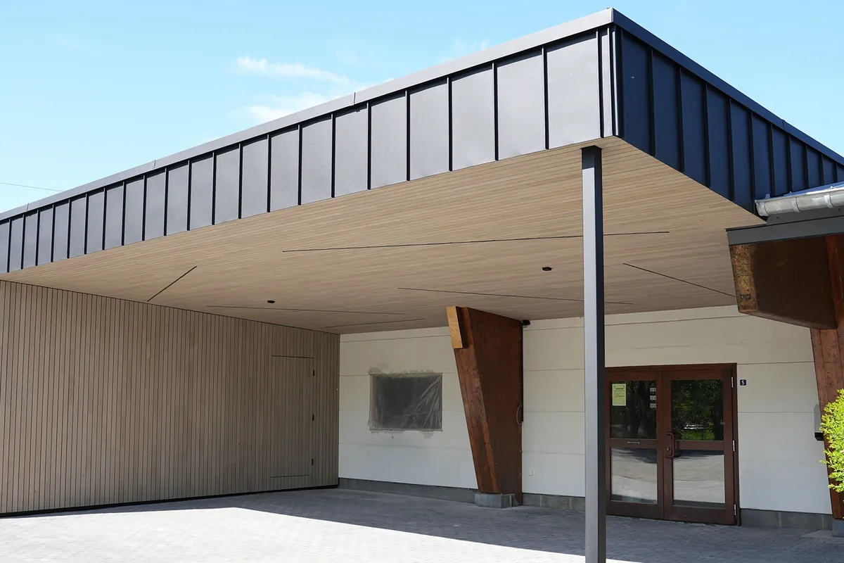 Eingangsüberdachung mit heller Holzuntersicht und dunkler Fassadenverkleidung