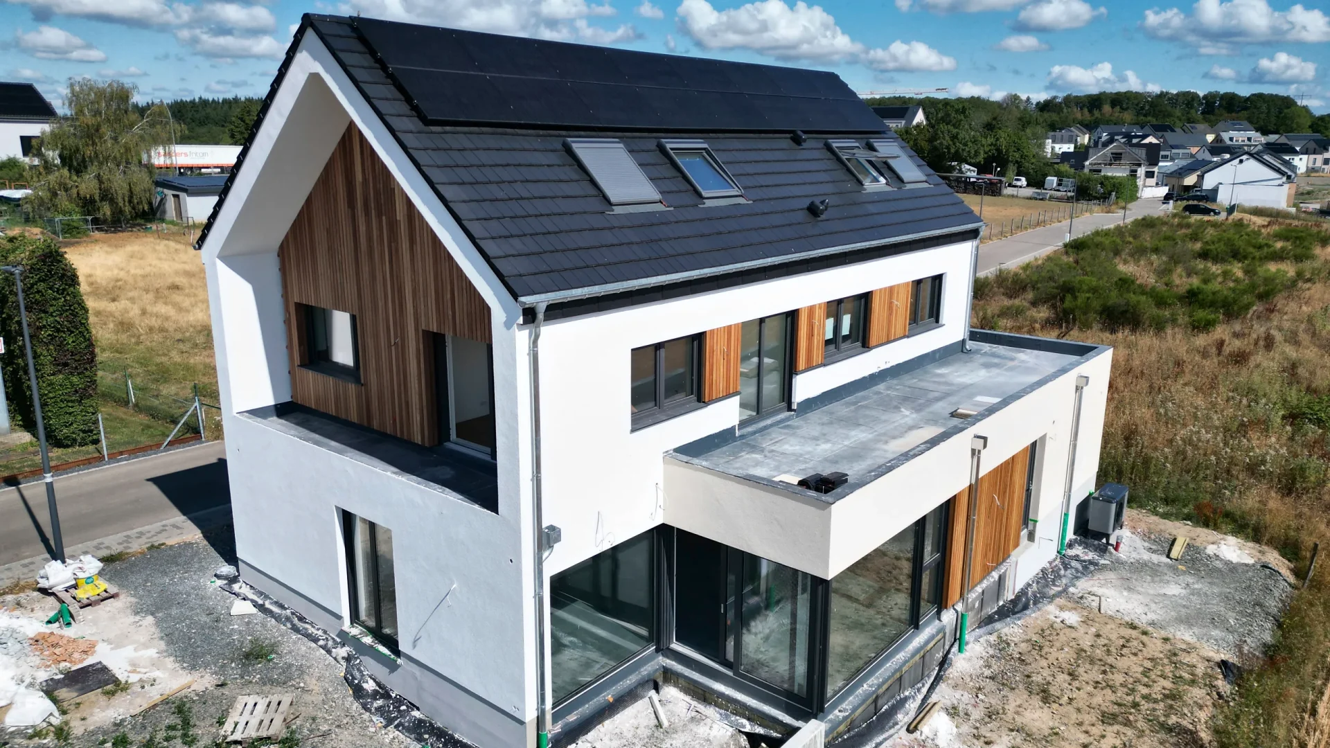 Fertiges Hybridhaus in Hoscheid-Dickt mit Giebel aus Holz, weißem Putz und dunklem Dach