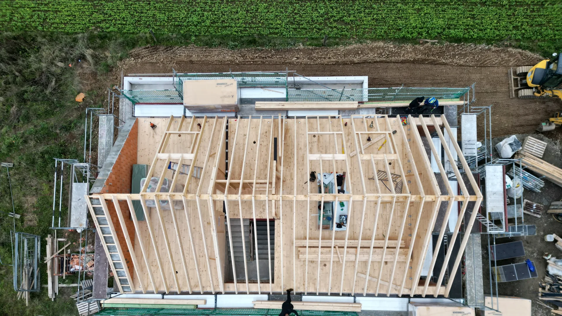 Blick von oben auf die Holzkonstruktion des Dachgeschosses über dem gemauerten Erdgeschoss