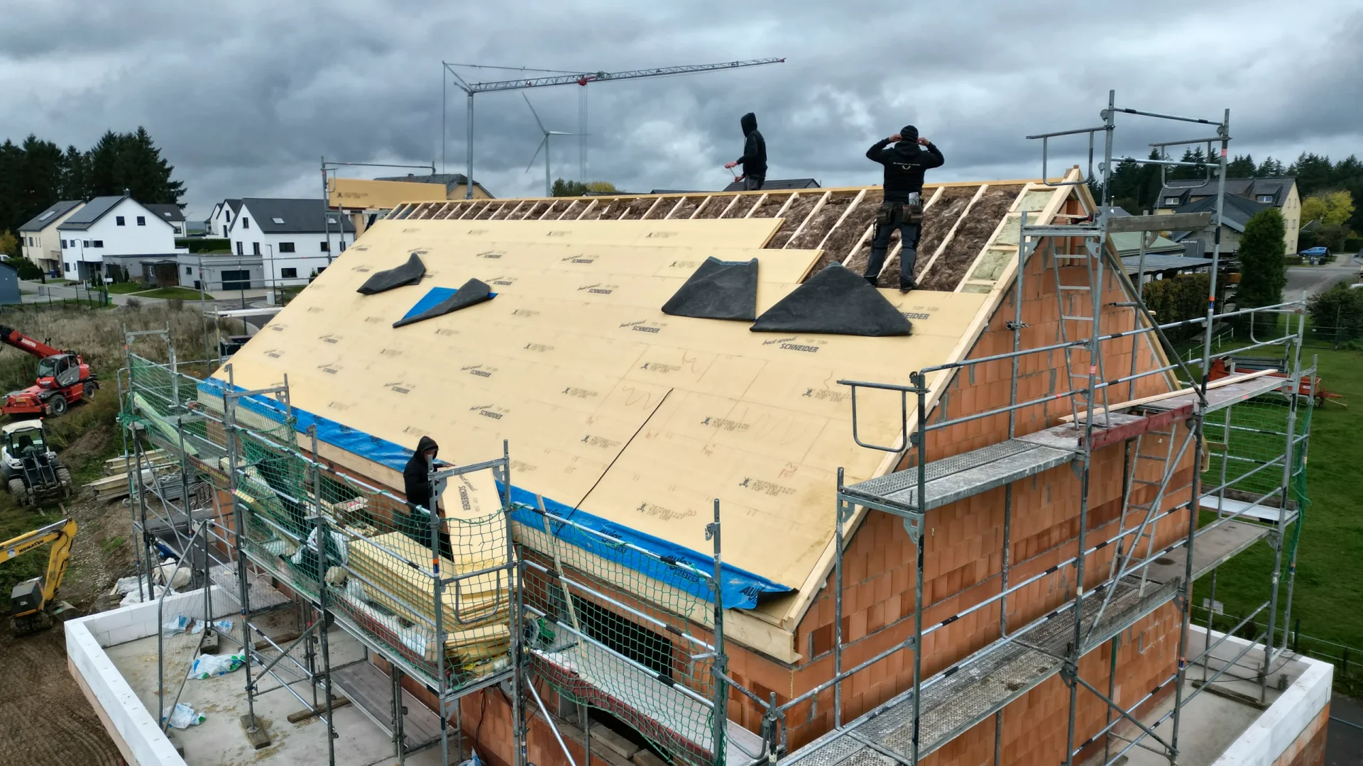 Das Satteldach wird mit Holzfaserplatten gedämmt, das Haus steht im Gerüst
